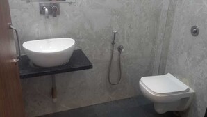 Un baño con lavamanos blanco, inodoro y ducha.