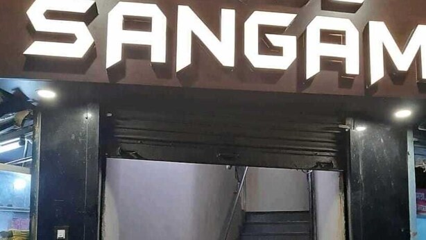 Una escalera que conduce a un edificio con un letrero que dice 'HOTEL SANGAM'.