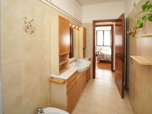 Ein Badezimmer mit zwei Waschbecken, einem Spiegel und einer Toilette.