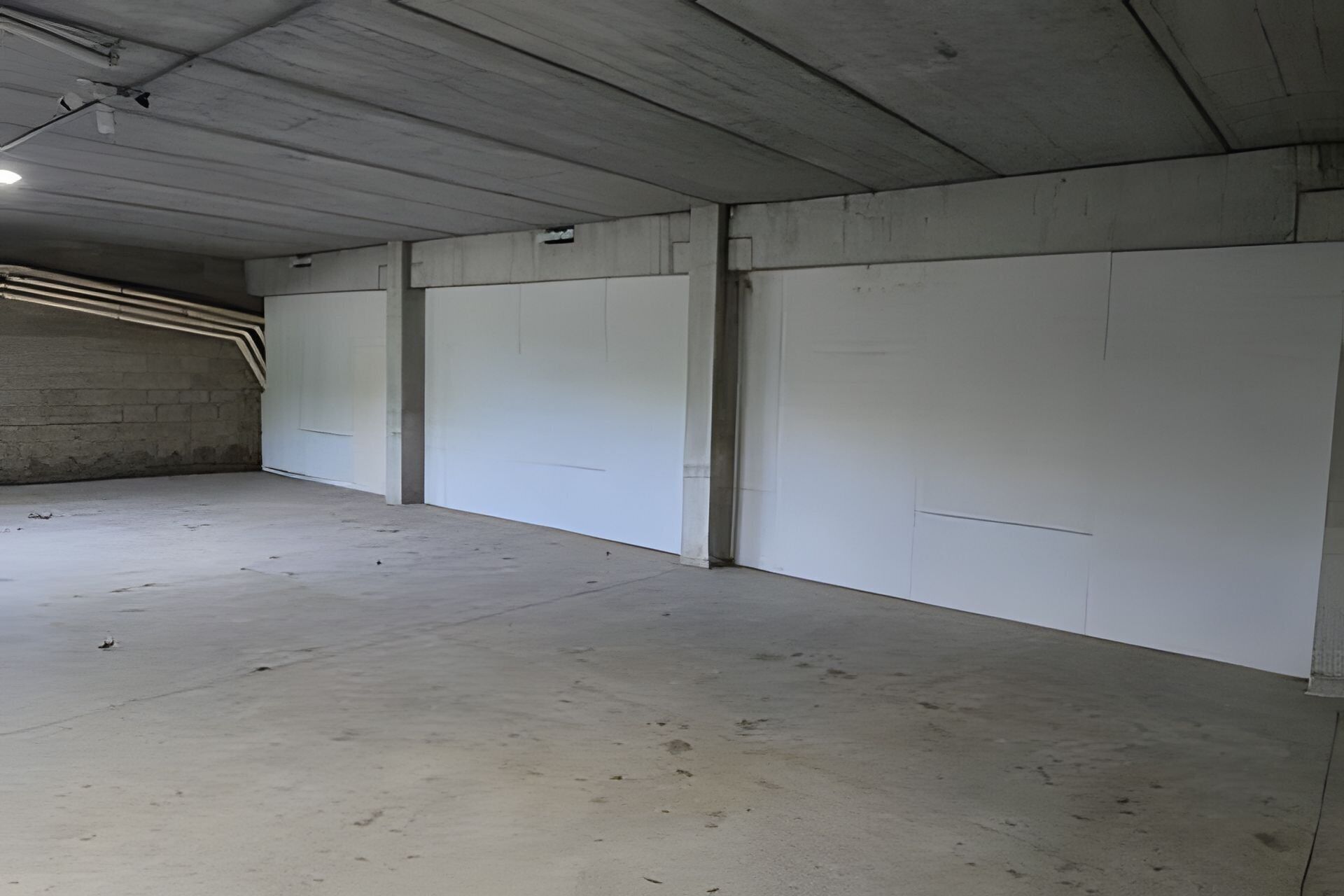 Une grande pièce vide aux murs en béton et au plafond plat.