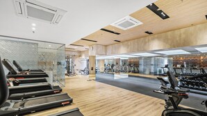 A gym with treadmills, exercise bikes, and weight machines. - Senso by Kozystay - Tanjung Barat (Jakarta)