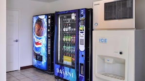 Un espace équipé d’un distributeur automatique de boissons, proposant des produits Pepsi et de l’eau Dasani, ainsi qu’un réfrigérateur à glaçons.