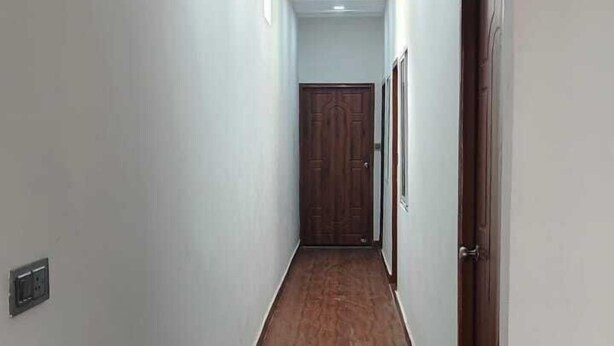 Ένας μακρύς, στενός διάδρομος με λευκούς τοίχους και ξύλινο δάπεδο.