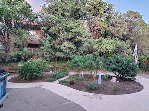 Un jardín ajardinado con diversas plantas y una estatua.