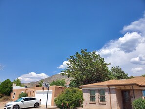 A residential area with houses, a white car, and a clear blue sky.