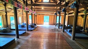 A spacious indoor area with a central walkway, seating areas on either side, and large windows allowing natural light. - Ban Lien Forest Homestay Lao Cai (Ban Lien)