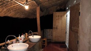 A rustic bathroom with two sinks, wooden stools, and a thatched roof. - Ban Lien Forest Homestay Lao Cai (Ban Lien)