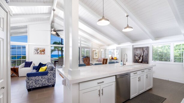 A spacious kitchen with white cabinetry, a large island, and a view of the outdoors. - Butterfly House:  Beautiful Ali'i Drive Home with Ocean Views! (Kailua-Kona)
