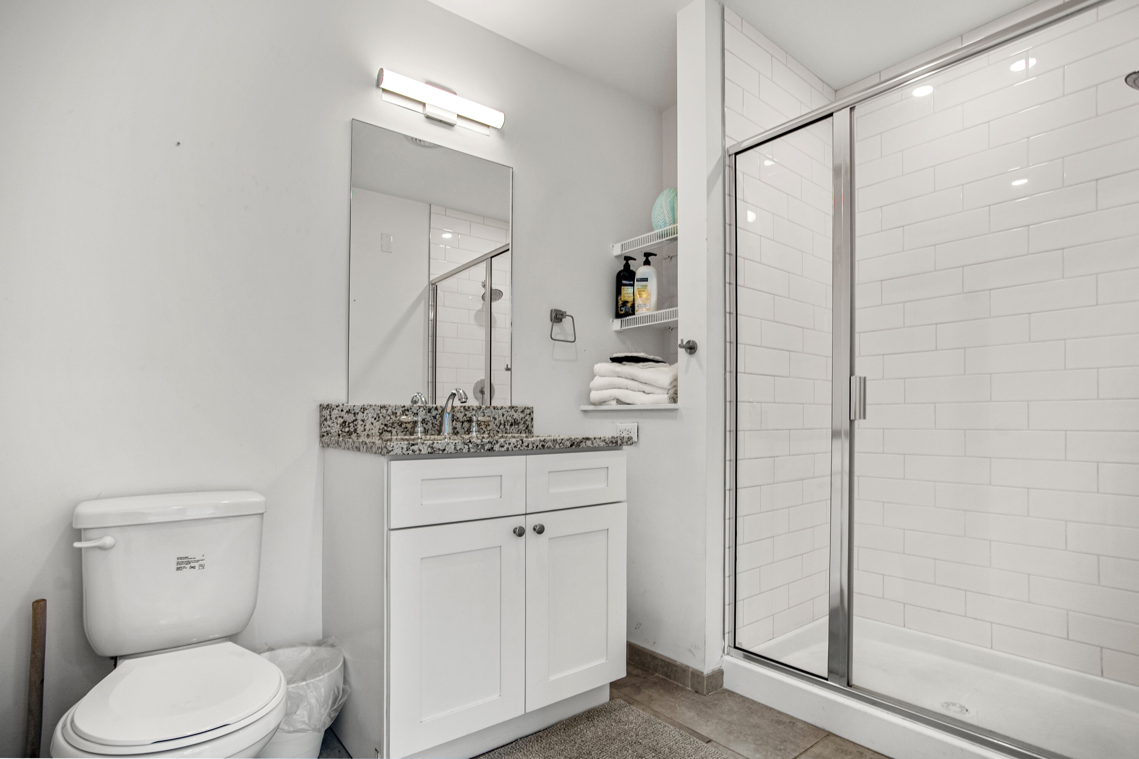 A modern bathroom with a toilet, sink, and shower.