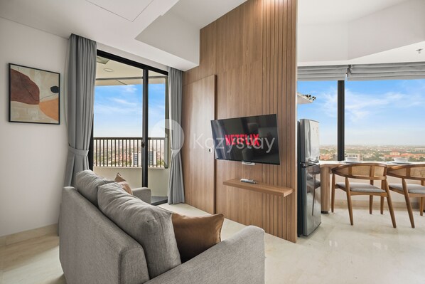 Relax in this stylish living room with a large flat-screen TV, comfortable sofa, and dining area.