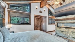 A bedroom with a large bed, a fireplace, and a view of the outdoors. - Fire and Ice/Northstar Resort Truckee, CA (Truckee)