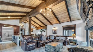 A spacious living room with a leather sofa, a wooden coffee table, and a large rug. - Fire and Ice/Northstar Resort Truckee, CA (Truckee)