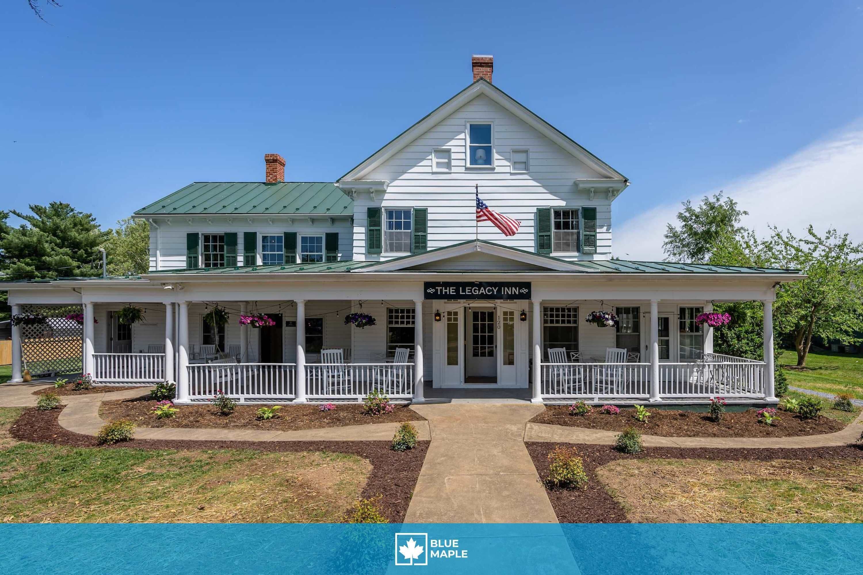 A two-story building with a porch, a flag, and a sign reading 'The Legacy Inn.'