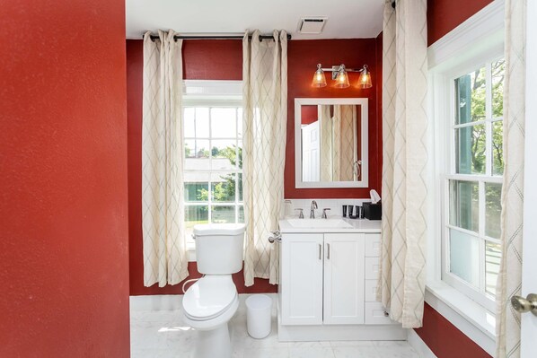 Un baño con inodoro, lavabo y espejo.