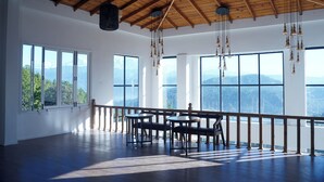 A spacious room with large windows, a wooden ceiling, and hanging light fixtures. - Spellmount - Himalayan View Infinity Pool Resort In Kausani (Kausani)