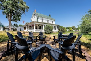 A house with a porch, outdoor seating, and a fire pit.