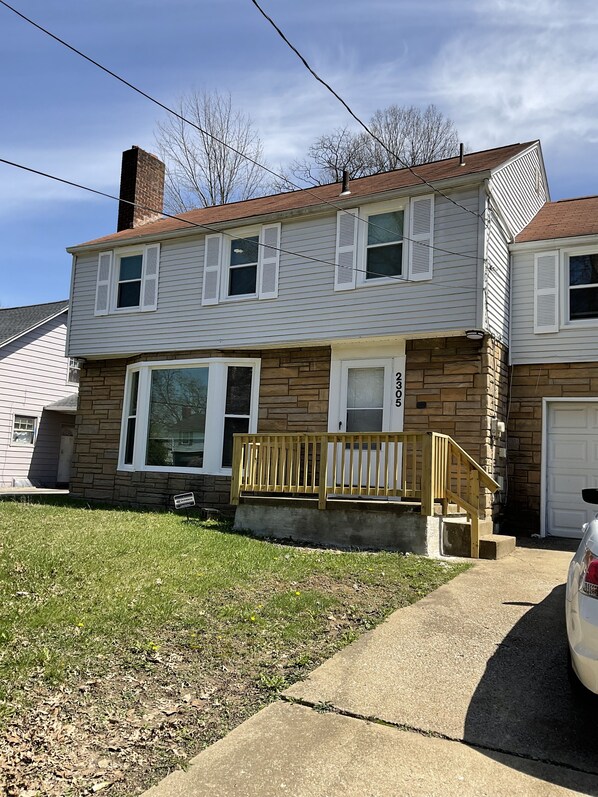 A two-story house with a front porch, a garage, and a driveway. - Prime location:Downtown/Campus (Youngstown)