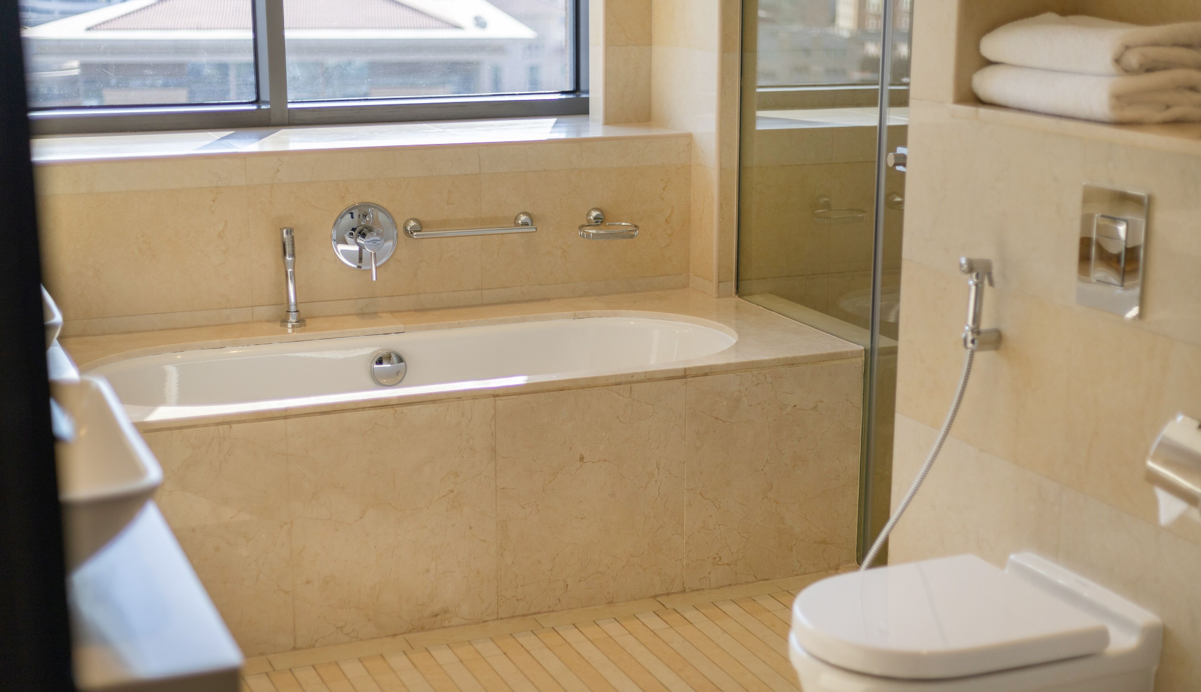 A modern bathroom with a bathtub, a glass shower enclosure, and a toilet.