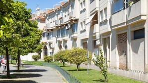 A row of modern apartment buildings with balconies, a paved pathway, and a metal fence. - sibssanlúcar Camelias (Sanlucar de Barrameda)