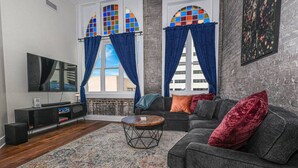 Una sala de estar moderna con un sofá gris, una mesa de centro, un televisor y una chimenea.