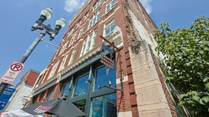 A historic building with a sign for 'Tavern Tequila Whiskey' and a 'No Parking' sign. - Downtown Luxury Condo | Near UT (Knoxville)