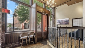Un restaurant avec une enseigne indiquant la sortie, des chaises en bois, un plancher en bois et une vue sur la rue.