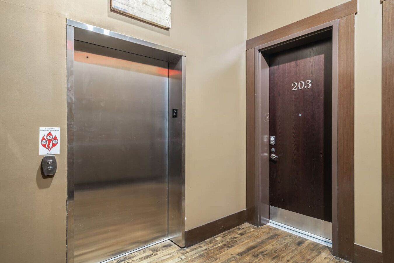 Un ascenseur et une porte portant le numéro 203.
