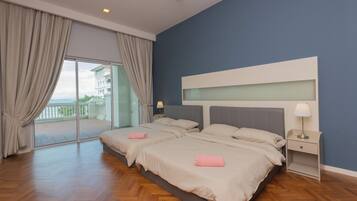 Quarto de hotel com duas camas, uma varanda e vista para um prédio.