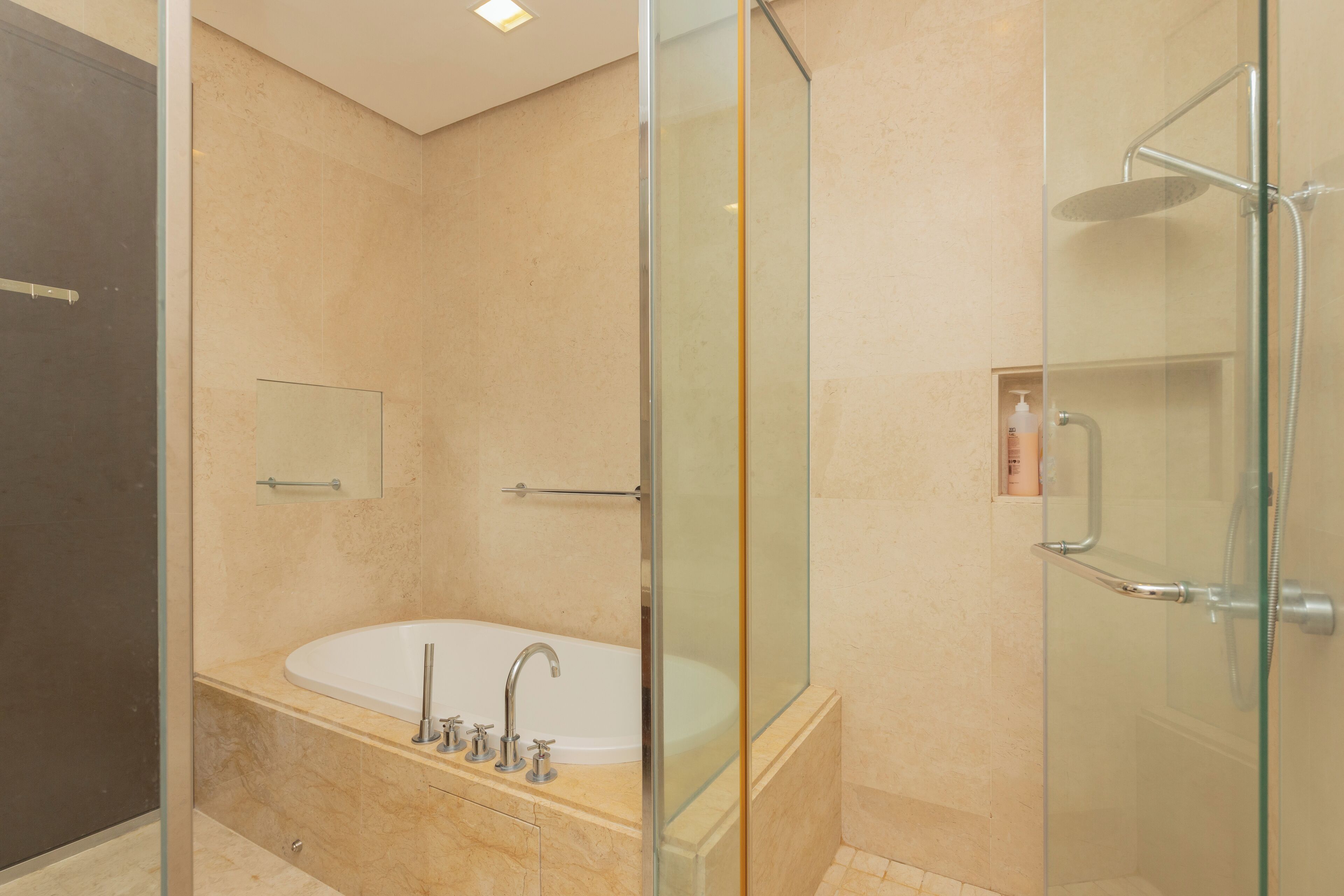 A modern bathroom with a glass-enclosed shower, a freestanding bathtub, and a glass shower door.