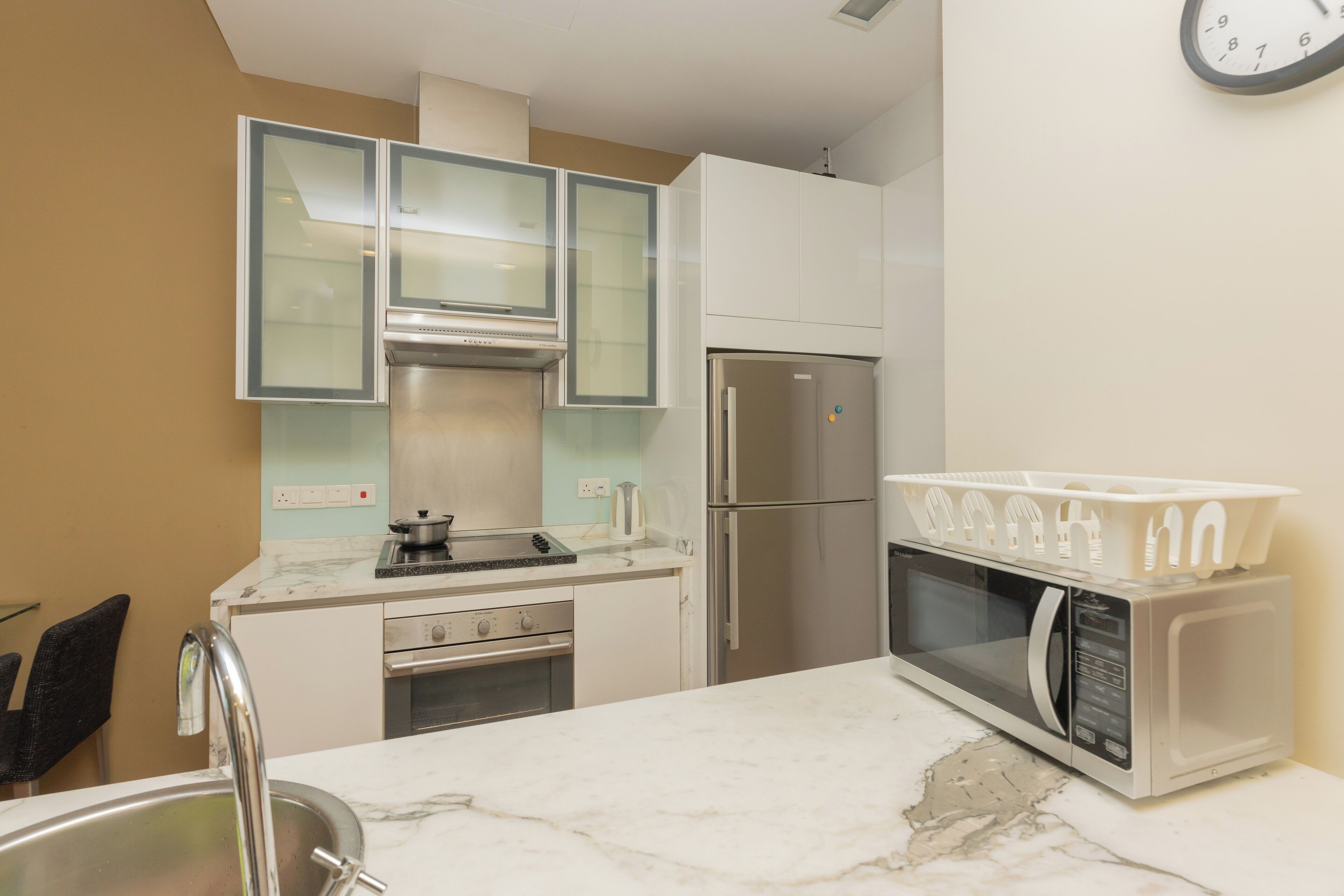A modern kitchen with a stainless steel refrigerator, a microwave, and a stove.