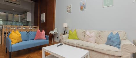Una sala de estar con dos sofás, una mesa de centro y una lámpara.