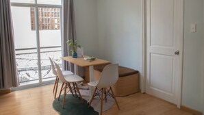 A room with a dining table, two chairs, a potted plant, and a sliding door. - Lumina Home (Ho Chi Minh City)