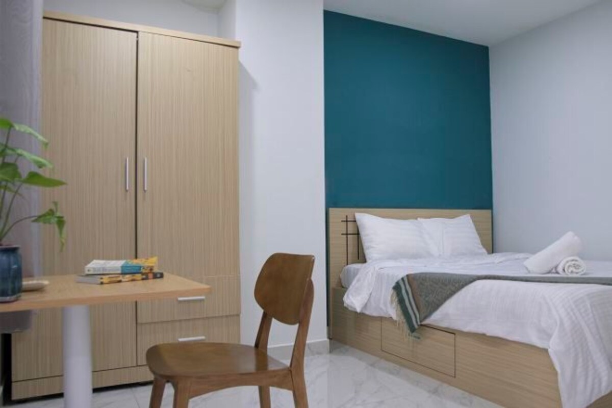 Un dormitorio con cama, escritorio y silla.
