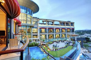 Un hotel moderno con piscina, area salotto all'aperto e vista sulla città.