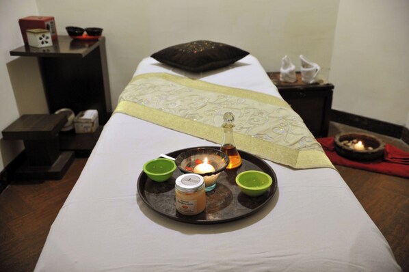 A massage table with a tray of candles, a jar, and two green bowls. - The BellaVista Hotel Chandigarh Panchkula (Panchkula)