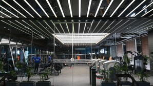 A modern gym with exercise equipment, glass walls, and a high ceiling with linear lighting. - The BellaVista Hotel Chandigarh Panchkula (Panchkula)