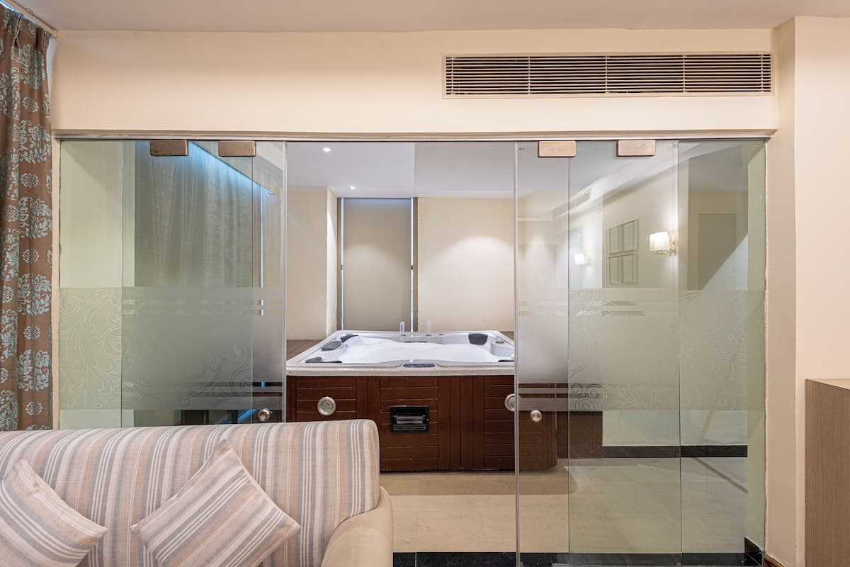A modern bathroom with a glass-enclosed shower, a wooden vanity, and a large bathtub.