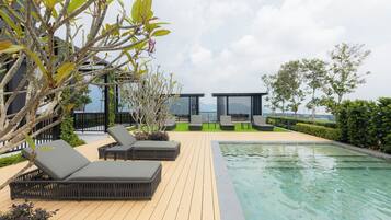 A poolside area with lounge chairs and a pool.