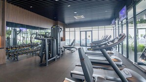 Ein Fitnessstudio mit Laufbändern, Kraftgeräten und Kurzhanteln.