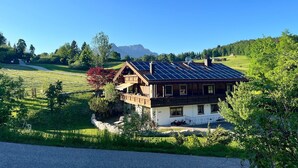 Un chalet doté d’un toit en pente, de panneaux solaires et de fondations en pierre.