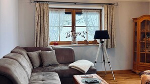Un salon chaleureux avec un canapé en cuir marron, une table basse en bois et un lampadaire.