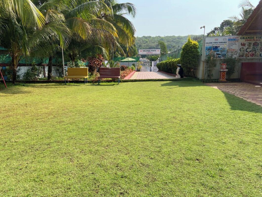 Un área verde bien cuidada con un banco y un letrero que indica Grande Vista.