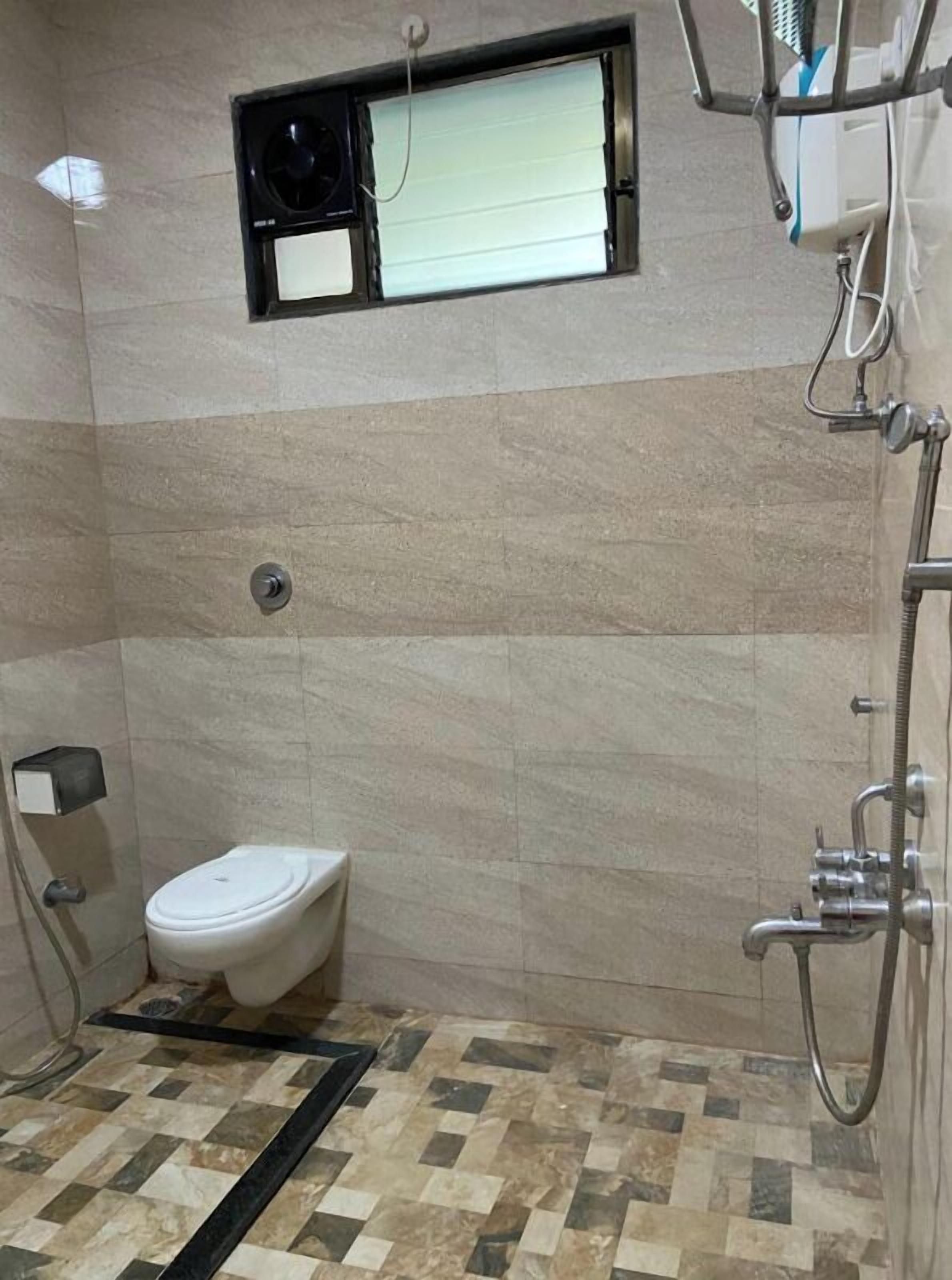 Ein Badezimmer mit Toilette, Dusche und Fenster.