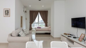 A modern bedroom with a bed, a TV, a desk, and a window with curtains. - Mansion One, by BAYAN (George Town)