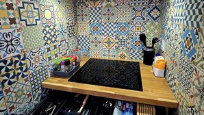 Eine Küche mit einem gemusterten Rückwand, einer Holzarbeitsplatte und einem integrierten Messerblock.