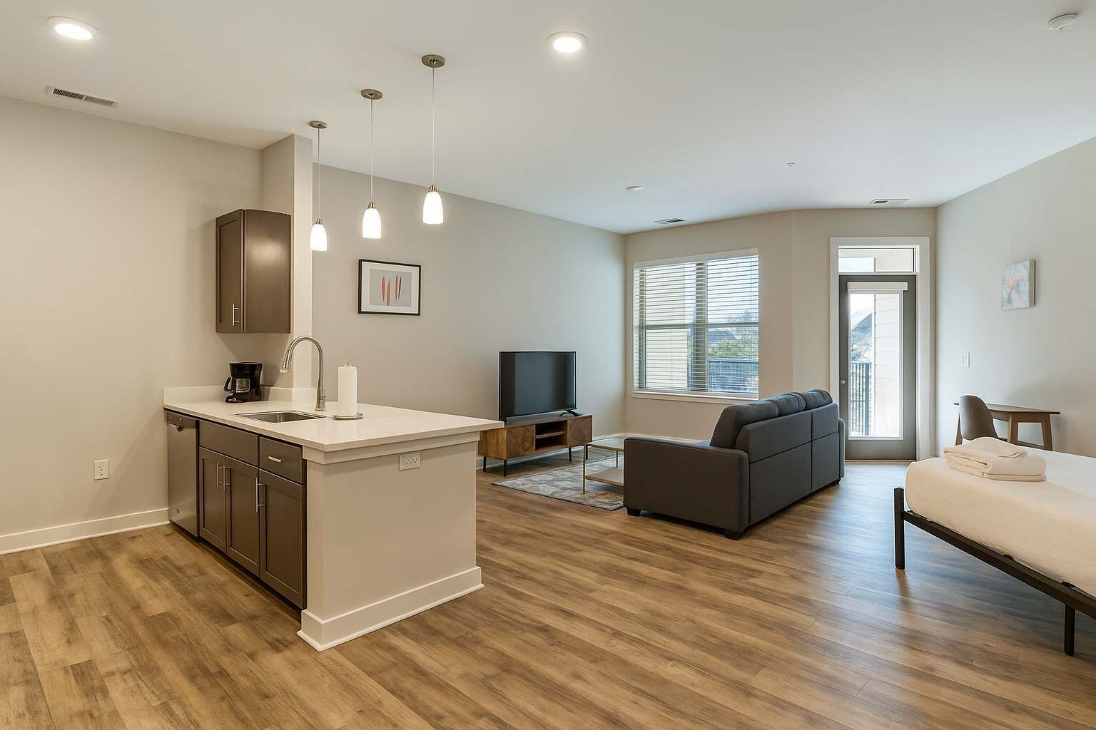 A modern apartment with a kitchen, living area, and balcony.