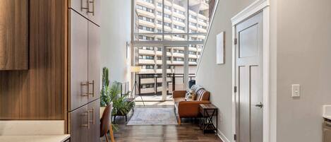 A modern apartment with a kitchen, living area, and a balcony with a city view.