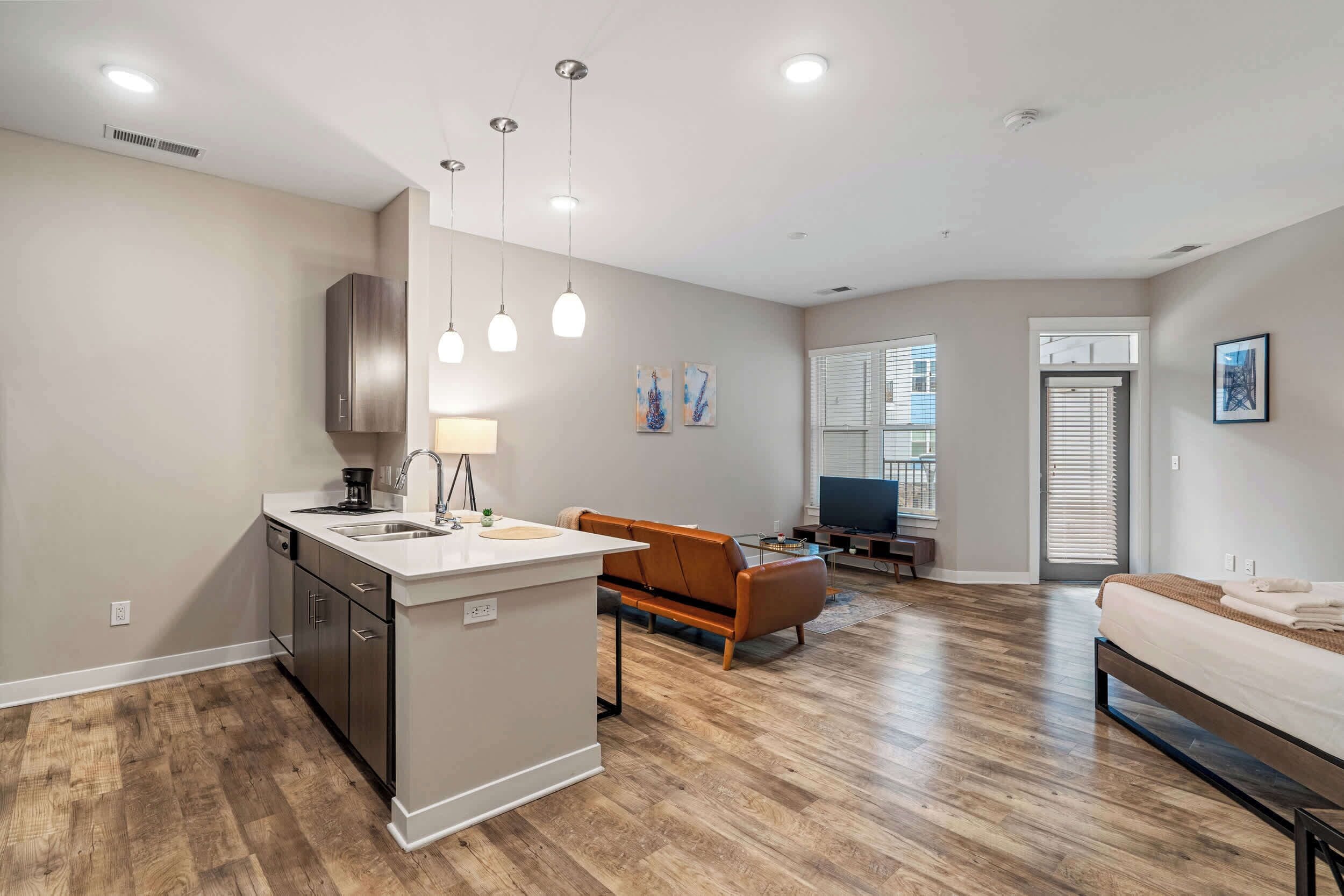 A modern apartment with a kitchen, living area, and bedroom.