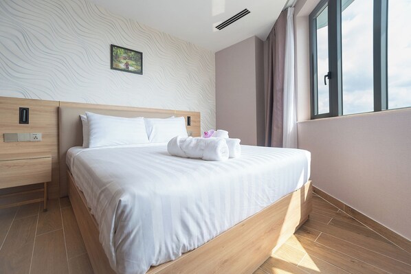 Una habitación de hotel moderna con una cama de madera, ropa de cama blanca, un cuadro en la pared y un ventanal con cortinas.