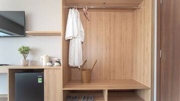 Ein modernes Badezimmer mit einem Holzkosmetikschrank, einem Waschbecken, einem kleinen Kühlschrank, einem Handtuchhalter und einem Schuhregal.